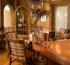霍尔德内斯金色池塘庄园旅馆的配有桌椅的用餐室和桌子上的饮品