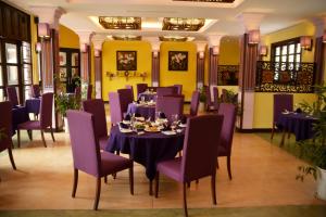 顺化顺化别墅酒店的一间带桌子和紫色椅子的用餐室