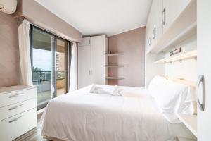 博索莱伊Appartement Le Corail Au Beausoleil - Happy Rentals的卧室设有白色的床和大窗户