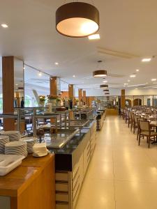 伊瓜苏Grand Carimã Resort & Convention Center的一间带桌椅的用餐室和一间自助餐厅