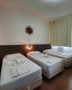 迪维诺波利斯Excellence Comfort Hotel的带窗户的酒店客房内的三张床