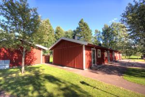 赖特维克Rättviks Golfby的前面有棵树的红色建筑