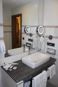 美因河畔法兰克福大帝国酒店 的一间带水槽和两面镜子的浴室