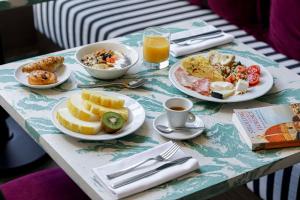 佛罗伦萨卢卡室友酒店的餐桌上摆放着早餐食品和橙汁盘