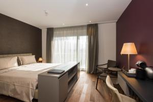 因特拉肯Hotel Du Nord的酒店客房配有一张床、一张书桌和电话