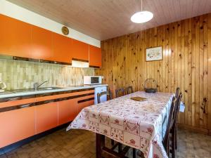 拉克吕萨Appartement La Clusaz, 3 pièces, 6 personnes - FR-1-437-10的一间带桌子的厨房和一间带橙色橱柜的厨房
