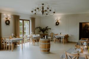 SławicaGościniec Winnica的一间带桌椅和吊灯的用餐室