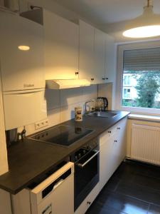 汉诺威Wohnung Hannover ogli的厨房配有白色橱柜和水槽