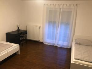 汉诺威Wohnung Hannover ogli的一间卧室配有一张床、一张书桌和一个窗户。