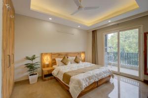 古尔冈1 BHK Serviced Apartments Near Millennium City Centre Gurugram with Private Washing Machine的一间带大床的卧室和一个阳台