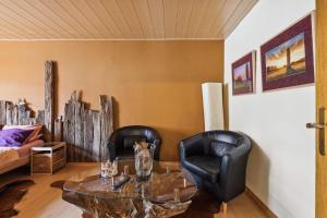 布利斯卡斯特尔Gästehaus Margerite的客厅配有2把黑色皮革椅子和桌子