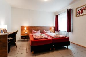 埃赫施塔特保加斯霍夫小号酒店的一间卧室配有红色的床和一张书桌