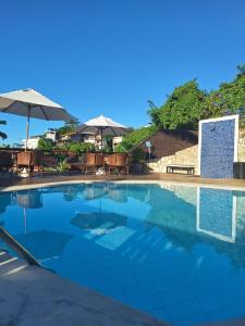莫罗圣保罗莫罗圣保罗酒店的一个带椅子和遮阳伞的大型游泳池