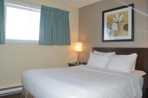 基洛纳希娅丝塔套房酒店的卧室设有一张白色大床和一扇窗户。
