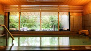 京都Kadensho, Arashiyama Onsen, Kyoto - Kyoritsu Resort的一个带大窗户的房间内的游泳池