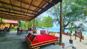 Phumĭ Kâoh RŏngEurope Enchanted Bungalow Koh Rong的海滩景门廊上的一张床位