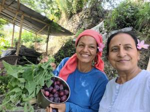 纳加阔特Sisters homestay的两个女人拿着一碗水果和蔬菜