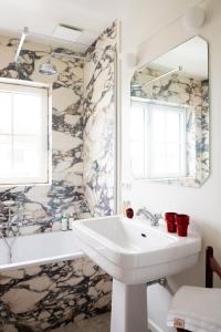 克诺克－海斯特Hotel Villa Bonnie的一间带水槽、浴缸和镜子的浴室