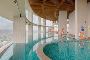 海阳Mandala Hotel & Suites Hai Duong的一座大型游泳池,位于一座景观建筑中