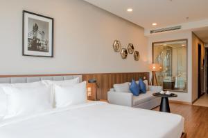 海阳Mandala Hotel & Suites Hai Duong的卧室配有白色的床和沙发