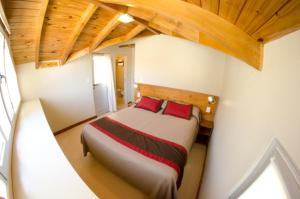 皮拉米德斯港德尔诺美德霍斯特利亚生态宾馆的一间卧室配有一张带红色枕头的大床