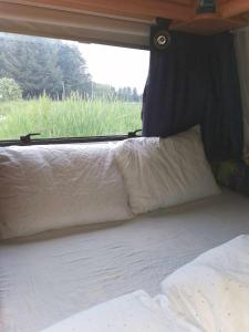 SynesVigra Glamping的一张位于野营车后面的床位,带窗户