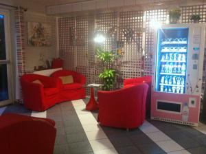 Nitry拉玛丽酒店的客厅配有红色椅子和苏打水机