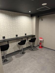 ŌsawaHotel Galaxy Pod的一间理发店,内设黑色椅子和柜台
