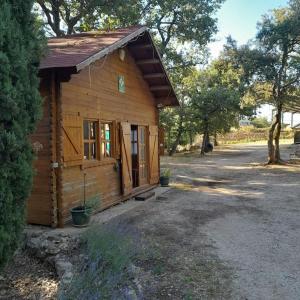 TourvesLa cabane en bois的小屋设有门廊和树木