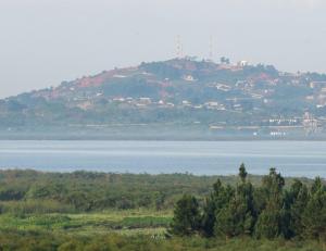 坎帕拉Hotel 256 Kampala, Kigo的一座大山,在水体旁边建有房屋