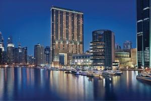迪拜JW Marriott Hotel Marina的水面上乘船的城市景观