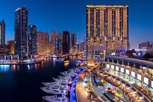 迪拜JW Marriott Hotel Marina的城市天际线,夜晚在水中划船