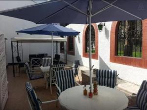 利马艾尔奥利瓦尔住宿加早餐旅馆 的一张桌子和椅子,配有蓝伞