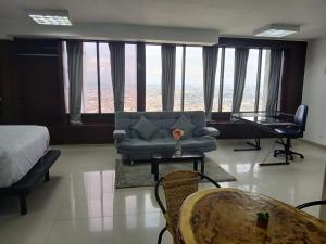 卡利TORRE DE CALI - Fabulosos Apartamentos pisos 6 al 39的一间带沙发、书桌和床的卧室