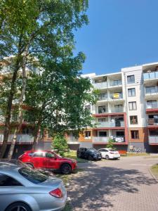 科沃布热格Komfortowy apartament w zachodniej części Kołobrzegu的停车场,停车场停在大楼前