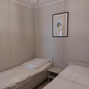 科沃布热格Komfortowy apartament w zachodniej części Kołobrzegu的一间设有两张床的客房,墙上挂着一张照片