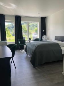StonglandseidetSenja Living的卧室配有床、桌子和窗户。