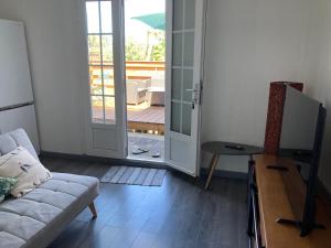 圣保罗Appartement Villèle的带沙发和滑动玻璃门的客厅