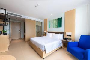Miếu ÔngArena Cam Ranh Bay Resort的一间卧室配有一张大床和一张蓝色的沙发