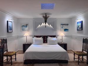 丹吉尔Riad Al-Qurtubi的一间卧室配有一张大床和两把椅子