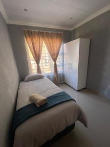 比勒陀利亚Mbobo Legacy Residence的一间卧室设有一张大床和窗户