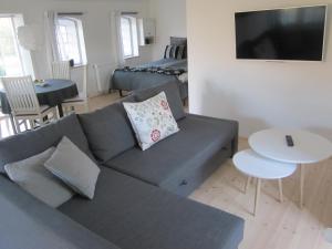斯文堡Tåsinge B&B的客厅配有灰色的沙发和床。