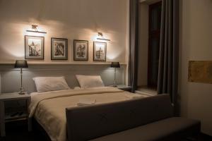 绿山城Hotel Retro B.A. Zientarski的卧室配有一张墙上三幅照片的床