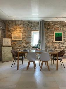 Agia TheodotiThe Artists House - Atelier Suite的一间设有桌椅和石墙的用餐室