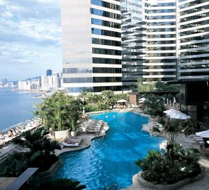 香港香港万丽海景酒店的一座带椅子的大型游泳池以及一座大型建筑