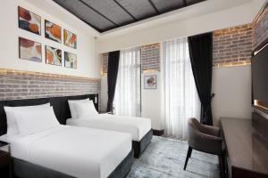 伊斯坦布尔DeCamondo Galata, a Tribute Portfolio Hotel的酒店客房配有两张床和一张书桌
