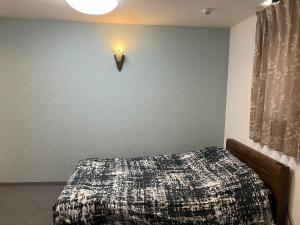 大阪HOTEL LEOLA - Vacation STAY 25772v的卧室配有一张床,墙上有灯