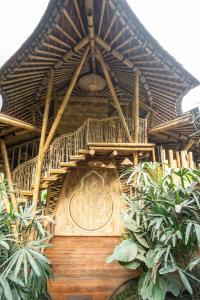 SelatMagic Hills Bali - Magical Eco-Luxury Lodge的植物建筑中的木楼梯