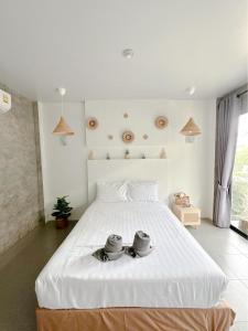 格兰岛Infinity Resort Kohlarn的一间卧室配有一张白色大床,上面放着两个碗