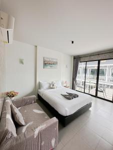 格兰岛Infinity Resort Kohlarn的一间卧室配有一张大床和一张沙发